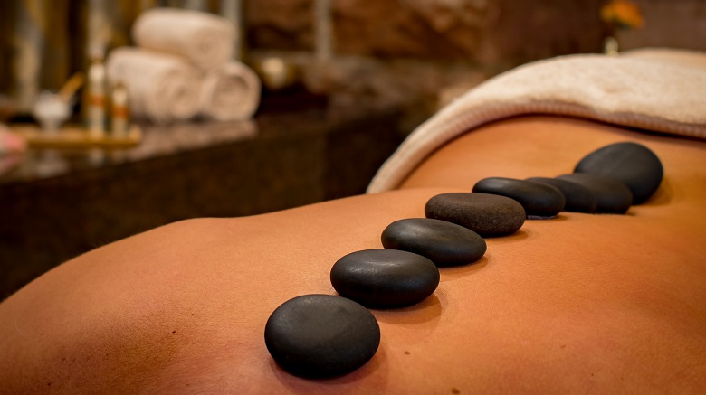 Lady receving a hot stones massage treatment